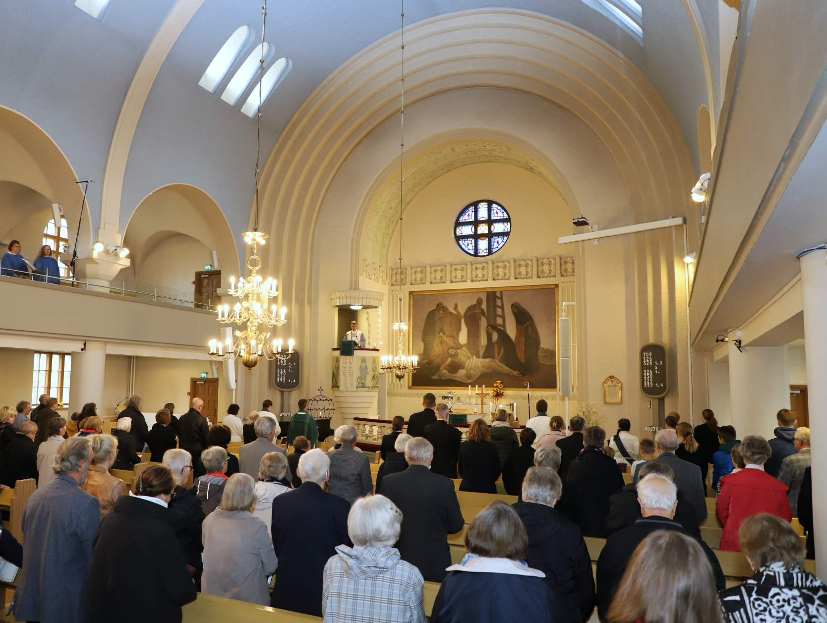 Alavuden kirkossa ihmisiä, Piispa Matti Salomäki saarnastuolissa. Ihmiset seisovat.