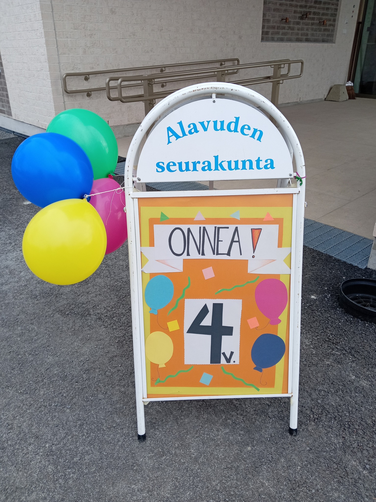 Taulu Onnea 4v. Taulussa kiinni ilmapalloja.